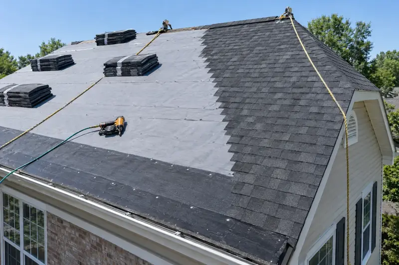 Roof mid-replacement with gray underlayment, ice and water shield at the eaves and new charcoal shingles on one side